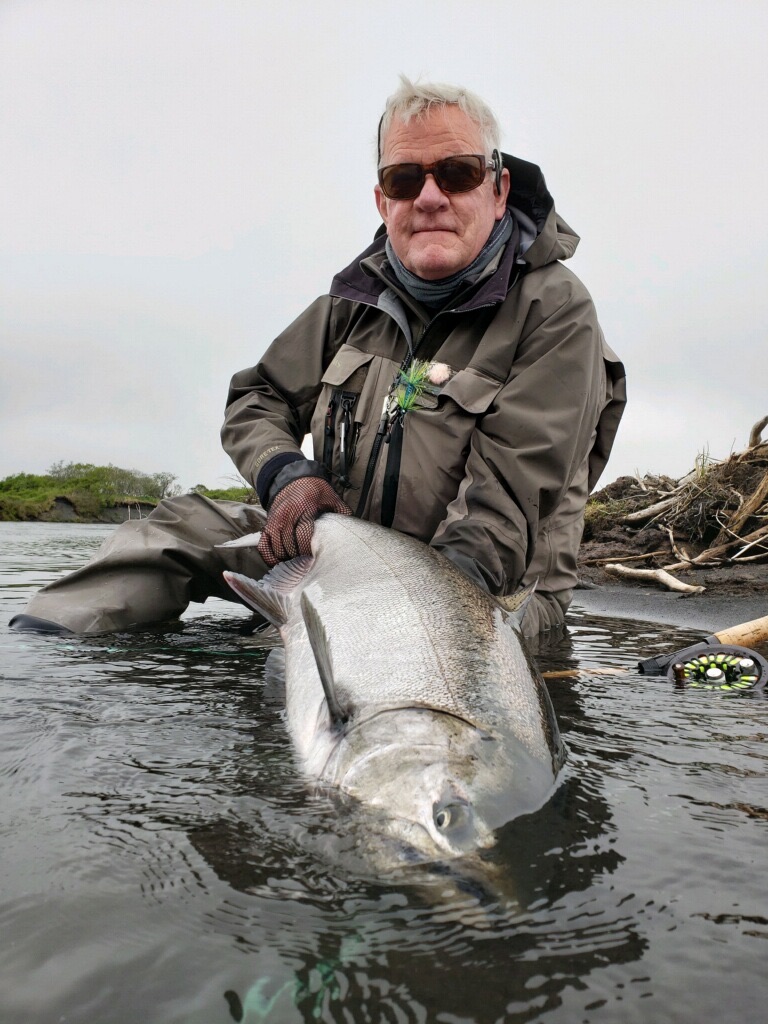 Chris Gill fishing catches huge sea-run king salmon out of water in Alaska Peninsula